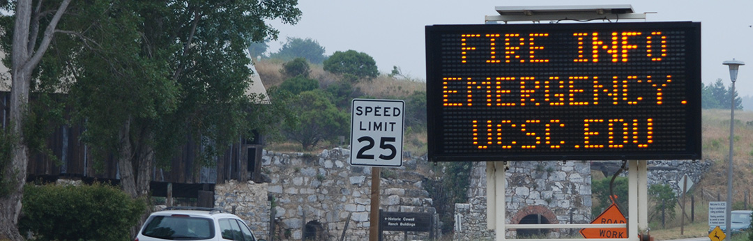 Photo of a roadsign with text reading Fire Info emergency.ucsc.edu